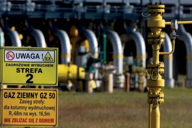 محطة غاز في بولندا مع لافتتين تحذران من الاقتراب منها (رويترز)