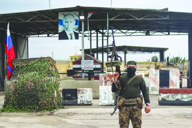 Lazkiye vilayetindeki Hmeymim Hava Üssü’nün girişi önünde yeni Suriye ordusundan bir asker, 29 Aralık 2024. (AFP)