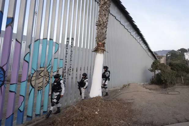 عناصر من الحرس الوطني المكسيكي يقومون بدورية على طول الجدار الحدودي الذي يفصل المكسيك عن الولايات المتحدة (أ.ب)