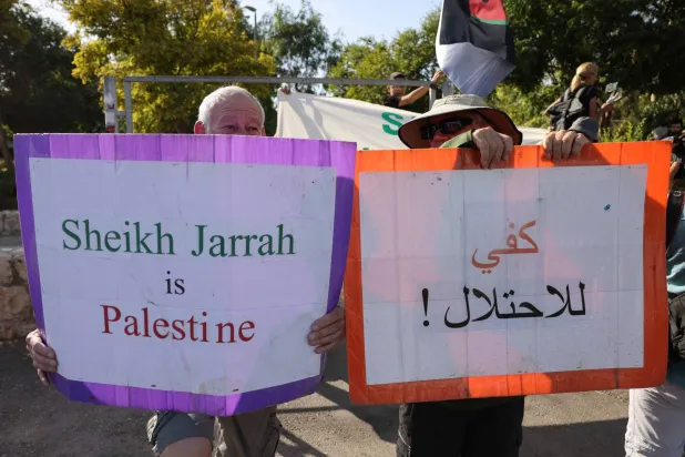 نشطاء سلام إسرائيليون وفلسطينيون يرفعون لافتات خلال مظاهرة ضد إخلاء الفلسطينيين من منازلهم في حي الشيخ جراح بالقدس الشرقية سبتمبر 2023 (أ.ف.ب)