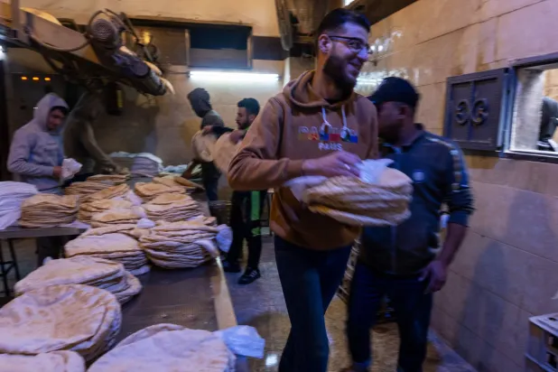 توزيع الخبز المدعوم في مخبز حكومي بمدينة حلب شمال سوريا (غيتي)