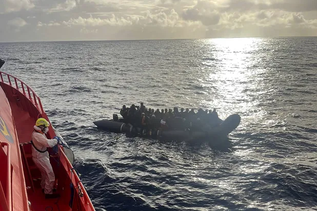 مهاجرون داخل قارب مطاطي وعلى متنه طفل وُلد في البحر يظهرون أثناء عبورهم المحيط الأطلسي للوصول إلى جزر الكناري (أرشيفية - أ.ب)