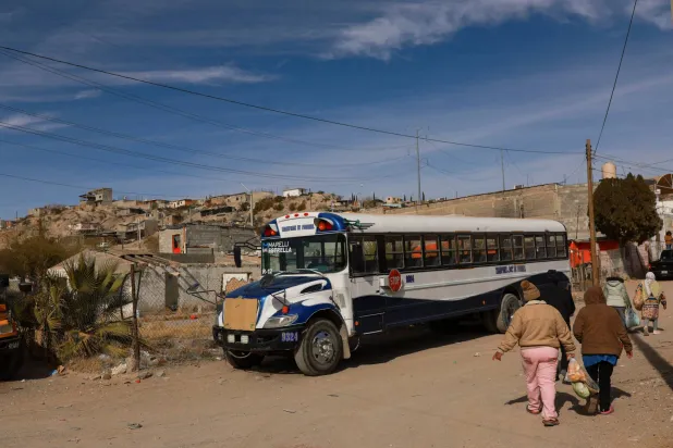 مهاجرة كولومبية تسير إلى ملجأ إل بوين ساماريتانو بعد التسوق في سيوداد خواريز بالمكسيك بالقرب من الحدود الأميركية (رويترز)