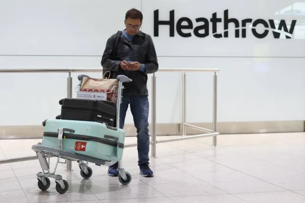 مسافر يستخدم جواله في مطار «هيثرو» بلندن (إ.ب.أ)