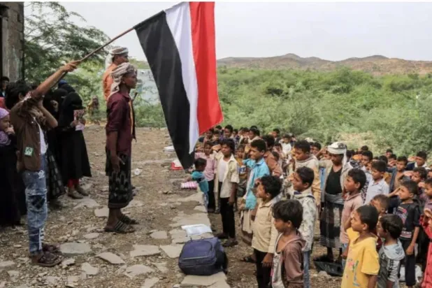 أطفال يمنيون قرب مدينة المخا يقفون أمام مبنى متهالك اتُّخذ كمدرسة مؤقتة (أ.ف.ب)