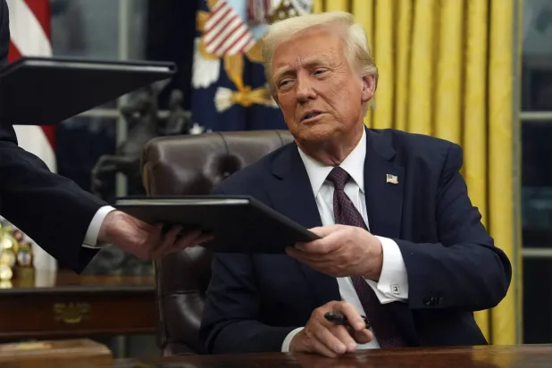 الرئيس الأميركي دونالد ترمب يوقع على أوامر تنفيذية في المكتب البيضاوي بالبيت الأبيض (أ.ب)