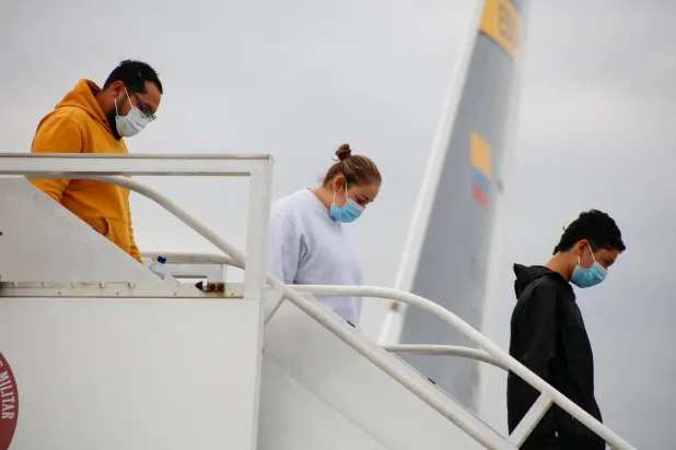 مهاجرون كولومبيون عائدون إلى بلادهم على متن رحلات عسكرية (رويترز)