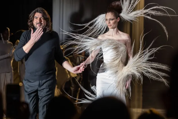 ستيفان رولان يُحيِّي ضيوفه في آخر العرض مع العارضة كوكو روشا (إ.ب.أ)