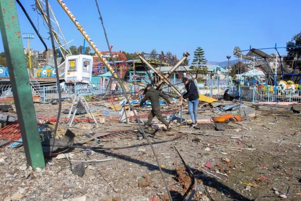 People clear debris at an amusement park that was hit in an Israeli airstrike a day earlier, in southern Lebanon's Nabatiyeh el Faouqa village on January 29, 2025. (Photo by Mahmoud ZAYYAT / AFP)