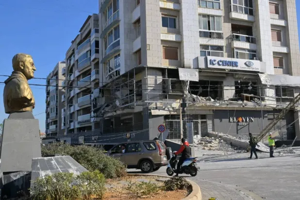 A statue of the late Iranian Quds Force commander Qasem Soleimani stands in front of a Qard al-Hasan center targeted by Israeli airstrikes (Asharq Al-Awsat) 