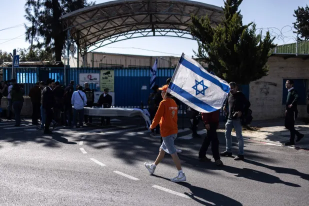 تجمع نشطاء من اليمين الإسرائيلي عند البوابة المغلقة لمكتب «أونروا» في الضفة الغربية في القدس الخميس (أ.ف.ب)