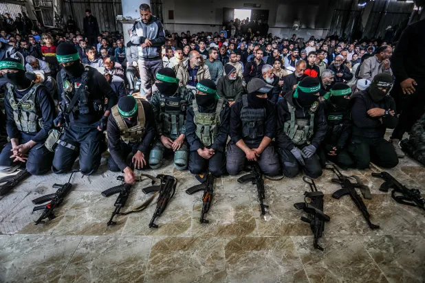 مقاتلون يشاركون في تشييع 15 مقاتلاً من «حماس» بخان يونس الجمعة (د.ب.أ)