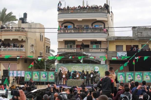 İsrailli rehineleri Gazze'nin merkezindeki Deyr el-Belah'te Kızıl Haç ekibine teslim etmeden önce onlara eşlik eden Hamas üyeleri, 8 Şubat 2025 (AFP)