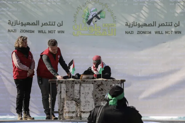 ممثل عن «حماس» يوقِّع على وثيقة قبل تسليمها لمسؤولين من الصليب الأحمر قبل إطلاق المحتجز الأميركي الأصل كيث سيغل في غزة السبت (د. ب. أ)
