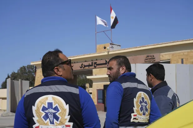 أفراد من خدمة الإسعاف ينتظرون أمام البوابة المصرية لمعبر رفح الحدودي مع قطاع غزة (أ.ب)