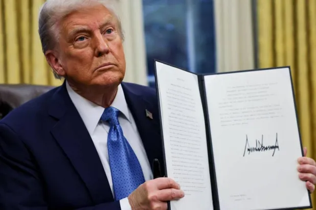 ترمب يظهر أمراً تنفيذياً بعد توقيعه في البيت الأبيض (رويترز)