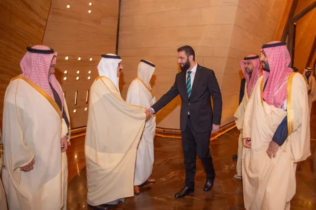 شاهزاده محمد بن سلمان در حال استقبال از الشرع. در این تصویر، مساعد العیبان، وزیر مشاور و دبیرکل شورای امنیت ملی سعودی (در حال دست دادن) و محمد آل شیخ، وزیر دولت و وزیر همراه، دیده می‌شوند