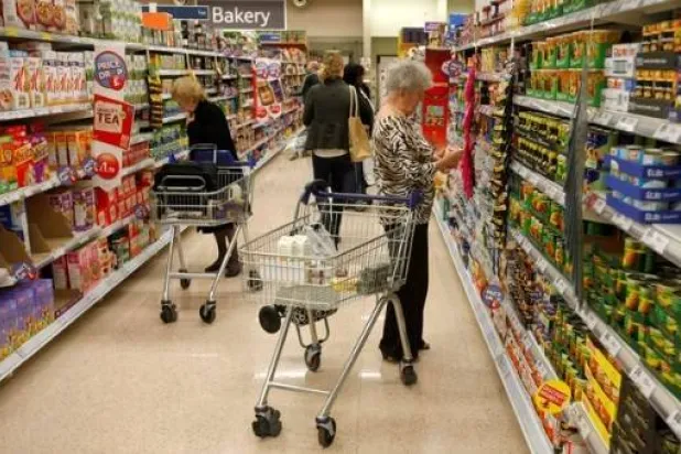يتسوق العملاء لشراء المواد الغذائية في سوبر ماركت في لندن (رويترز) 