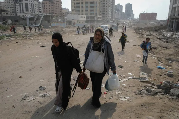 عائلة فلسطينية تعود إلى منزلها في غزة سيراً على الأقدام (رويترز)