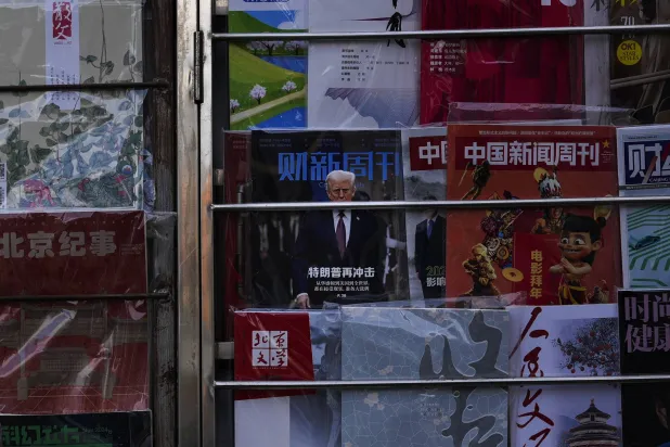 مجلة في واجهة أحد المحلات وسط العاصمة الصينية بكين تحمل صورة الرئيس الأميركي وتحتها تعليق «ترمب يضرب مجدداً» (أ.ب)