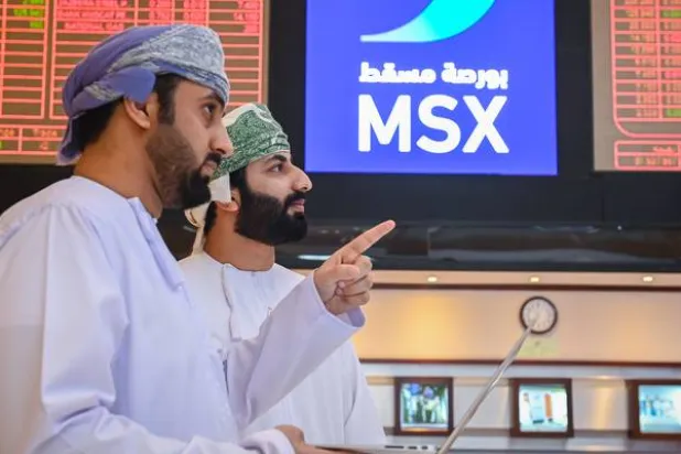متعاملان يتابعان أسعار الأسهم في بورصة مسقط (وكالة الأنباء العمانية)