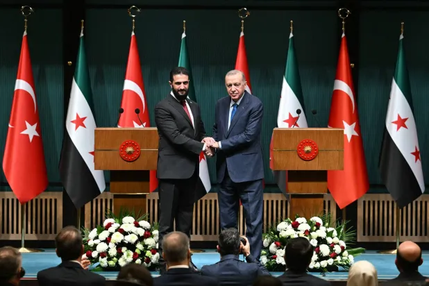 الرئيس التركي رجب طيب إردوغان والرئيس السوري في المرحلة الانتقالية أحمد الشرع يتصافحان بعد مؤتمر صحافي مشترك أعقب اجتماعهما في القصر الرئاسي في أنقرة (أ.ف.ب)