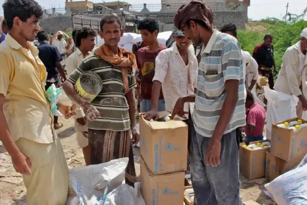 Yemenis displaced from the port city of Hodeidah receive humanitarian aid donated by the WFP in the northern province of Hajjah. (AFP)  