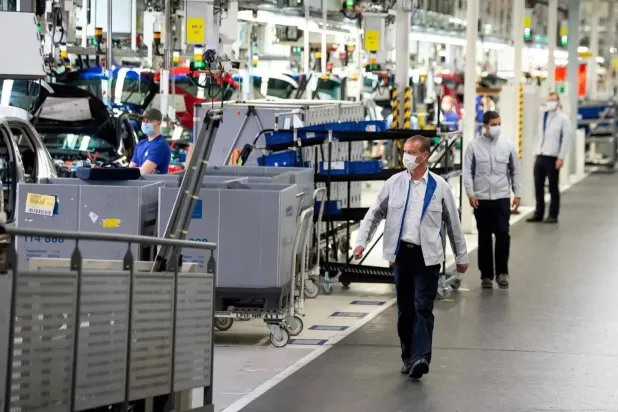 فنيون بجانب خطوط الإنتاج في أحد مصانع ألمانيا (رويترز)