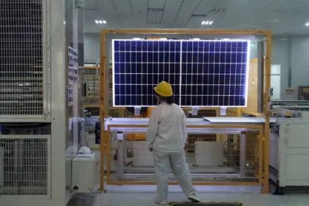 عامل يفحص وحدة طاقة شمسية بمصنع في الصين (رويترز)