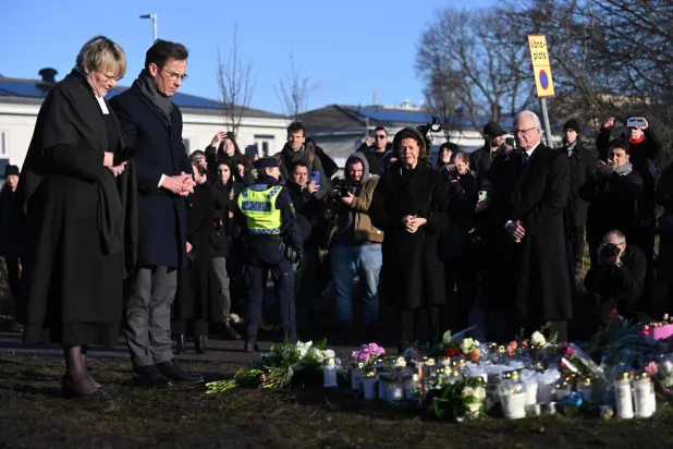 ملك وملكة السويد ورئيس الوزراء وزوجته يضعون وروداً في موقع الهجوم في أوريبرو 5 فبراير (أ.ف.ب)