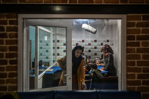 تُظهِر هذه الصورة الملتقطة في 28 نوفمبر 2021 مدرسين وطلاباً يحضرون فصلاً دراسياً على الهواء مباشرة في «راديو بيغوم» في كابل (غيتي)