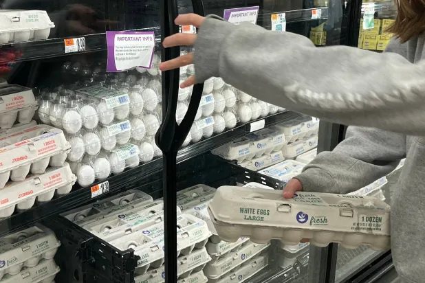 يلتقط أحد العملاء علبة بيض لشرائها في متجر بقالة عملاق في ماكلين بولاية فيرجينيا (أ.ف.ب)
