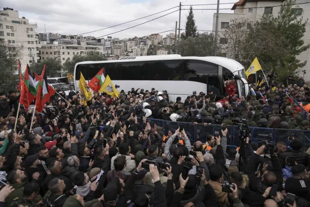 استقبال الأسرى الفلسطينيين عند خروجهم من حافلة «الصليب الأحمر» بعد إطلاق سراحهم من السجون الإسرائيلية في أعقاب اتفاق وقف إطلاق النار (أ.ب)