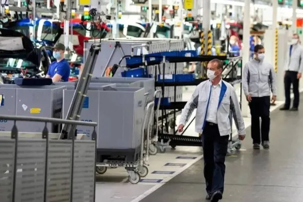 فنيون بجانب خطوط الإنتاج في أحد مصانع ألمانيا (رويترز)