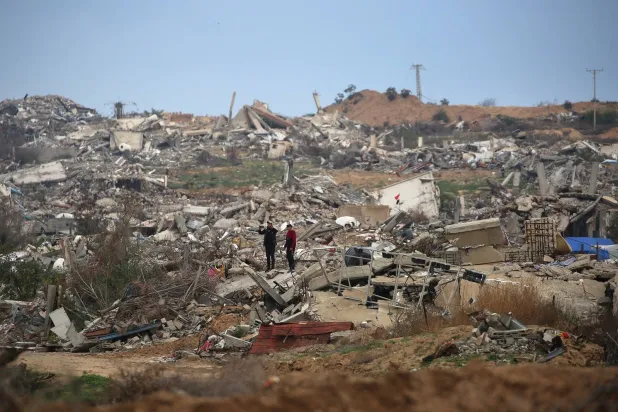 نازحون فلسطينيون يتفقدون الأضرار في شمال مدينة غزة (أ.ف.ب)