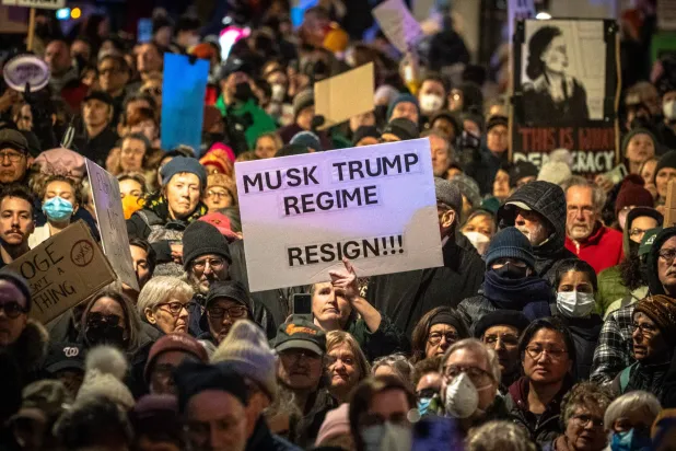 متظاهر يحمل لافتة خلال احتجاج خارج وزارة الخزانة الأميركية في واشنطن (د.ب.أ)