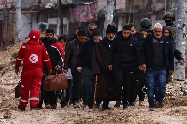 Israeli soldiers keep watch as Palestinians leave their homes for safety during a raid by the army in the Nur Shams refugee camp near Tulkarm in the occupied West Bank on February 10, 2025. (AFP) 