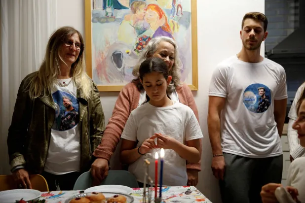 إيديت أوهيل (يسار)، والدة ألون أوهيل الذي اختطفته «حماس» خلال هجوم 7 أكتوبر تحتفل بالليلة الأولى من عيد الحانوكا اليهودي مع عائلتها، في منزلهم بشمال إسرائيل، 7 ديسمبر 2023 (رويترز)