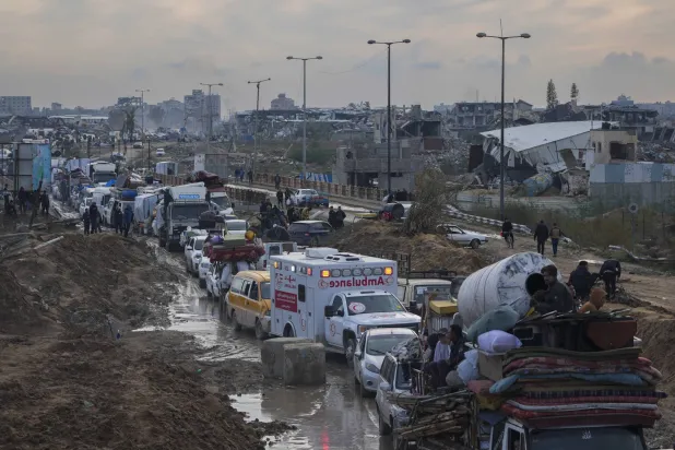 نازحون فلسطينيون يحملون أمتعتهم في المركبات ينتظرون عند نقطة تفتيش أمنية في ممر نتساريم في أثناء انتقالهم من وسط غزة إلى منازلهم في شمال قطاع غزة 11 فبراير 2025 (أ.ب)
