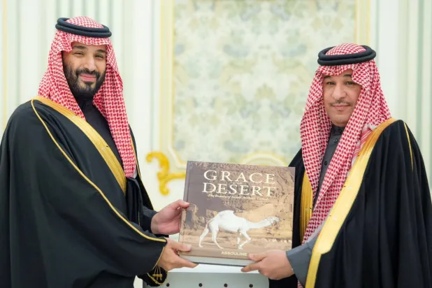 ولي العهد يتسلم هدية تذكارية من فهد بن حثلين المشرف على المهرجان (واس)