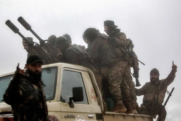 عناصر مسلحة في موقع على طول سلسلة جبال لبنان الشرقية بالقرب من القصير في غرب محافظة حمص السورية (أ.ف.ب)