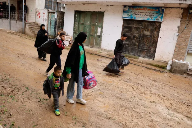 عائلة فلسطينية تنزح من مخيم «نور شمس» بعد أوامر الاحتلال الإسرائيلي بإخلائه فوراً (رويترز)