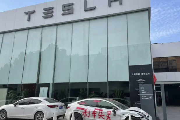 سيارة تشانغ ياتشو المتضررة تظهر أمام مقر شركة  «تسلا» في تشنغتشو بالصين (أ.ب)