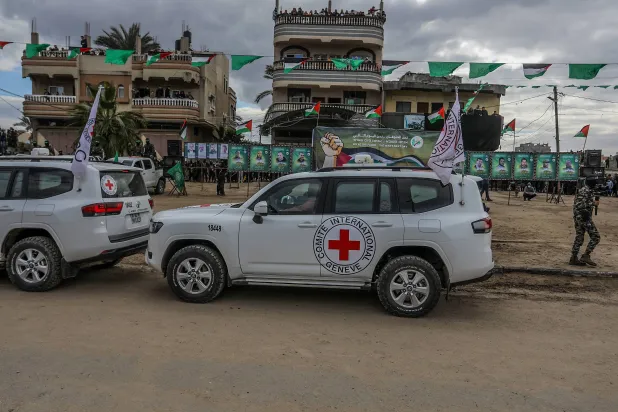 صورة ملتقطة في 8 فبراير 2025 في دير البلح بقطاع غزة خلال تسليم رهائن إسرائيليين لممثلي اللجنة الدولية للصليب الأحمر من قبل مقاتلي «كتائب القسام» الجناح العسكري لحركة «حماس» ضمن الدفعة الخامسة من المرحلة الأولى لصفقة التبادل (د.ب.أ)