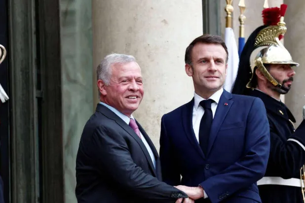 الرئيس الفرنسي إيمانويل ماكرون يرحب بالعاهل الأردني عبد الله الثاني لدى وصوله لحضور اجتماع في باريس 16 فبراير 2024 (رويترز)