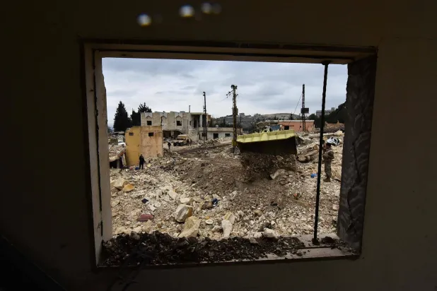 Lebanese soldiers watch as a military bulldozer reopens a road after army deployment as residents of the southern village of Rabb Thlathin return to their town on February 9, 2025. (Photo by Fadel ITANI / AFP)