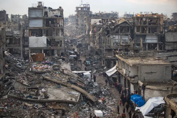 فلسطينيون يسيرون وسط الدمار الذي خلفته الغارات الجوية والبريّة الإسرائيليّة على جباليا قطاع غزة (أ.ب)