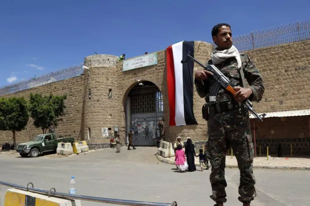 عنصر حوثي يحرس السجن المركزي في صنعاء الذي استولت عليه الجماعة منذ 11 عاماً (غيتي)