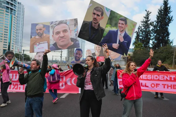 أقارب وأنصار الإسرائيليين المحتجَزين في غزة منذ هجمات 7 أكتوبر 2023 يغلقون طريقاً بتل أبيب خلال احتجاج يطالب بالإفراج عن جميع الرهائن 13 فبراير 2025 (أ.ف.ب)