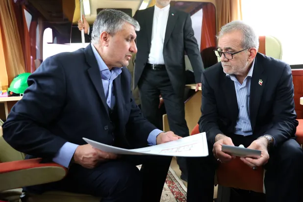 رئيس المنظمة الإيرانية للطاقة الذرية محمد إسلامي يتحدث إلى بزشكيان حول محطة بوشهر النووية (الرئاسة الإيرانية)